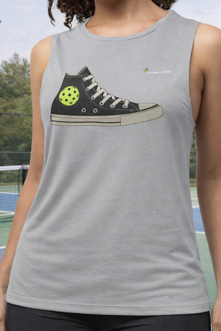Person wearing a tank top with a graphic of a sneaker and pickleball ball on a tennis court background