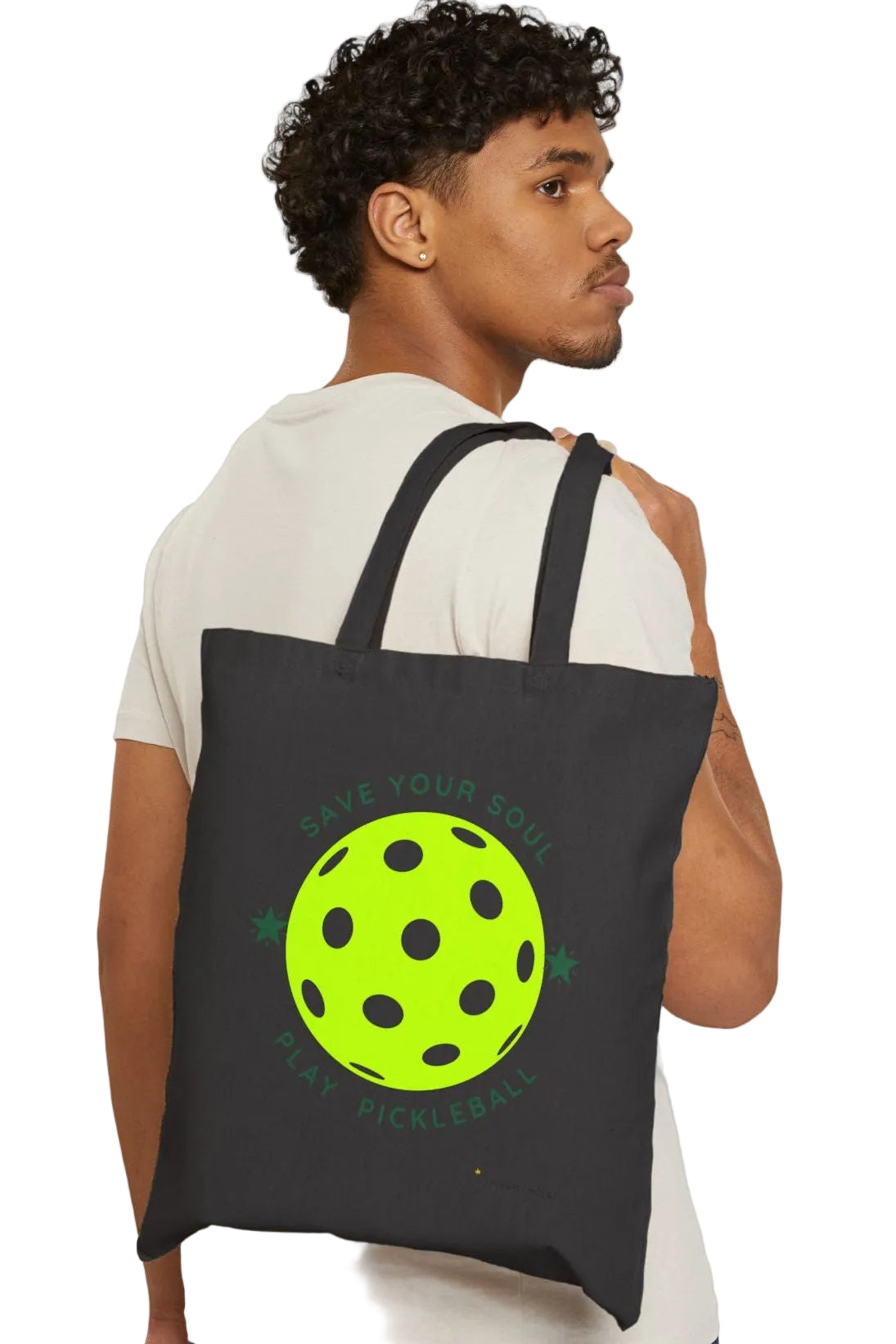 Man carrying a black tote bag with a green graphic on a white background