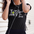 Woman wearing a black 'LOVE' t-shirt with earphones, standing against a light-colored wall.