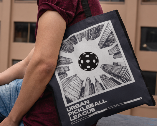 Man holding a tote bag with a geometric design against an urban background