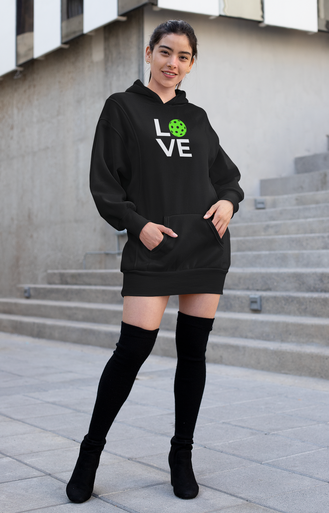 Person wearing a black hoodie with 'LOVE' printed on it, standing on steps.
