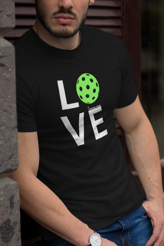 Person wearing a black t-shirt with 'LOVE' printed on it, leaning against a wall.