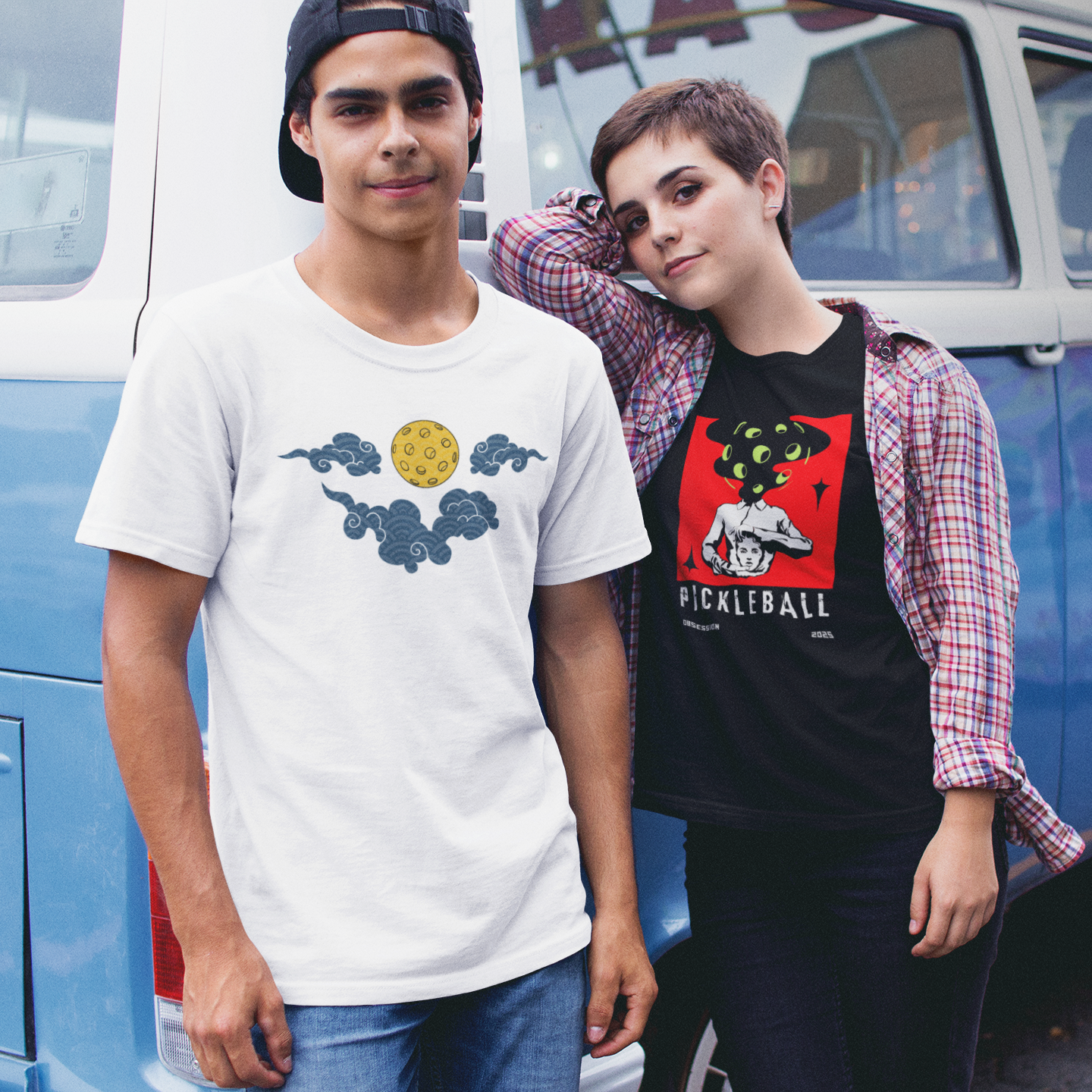 Two people standing in front of a blue van with a colorful design.