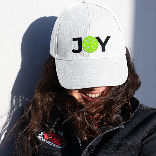 Person wearing a white cap with 'JOY' printed on it, against a plain background