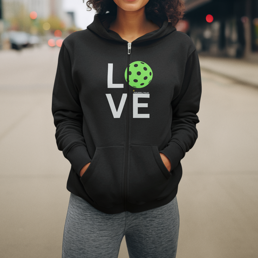 Person wearing a black hoodie with 'LOVE' and a pickleball design on a street.