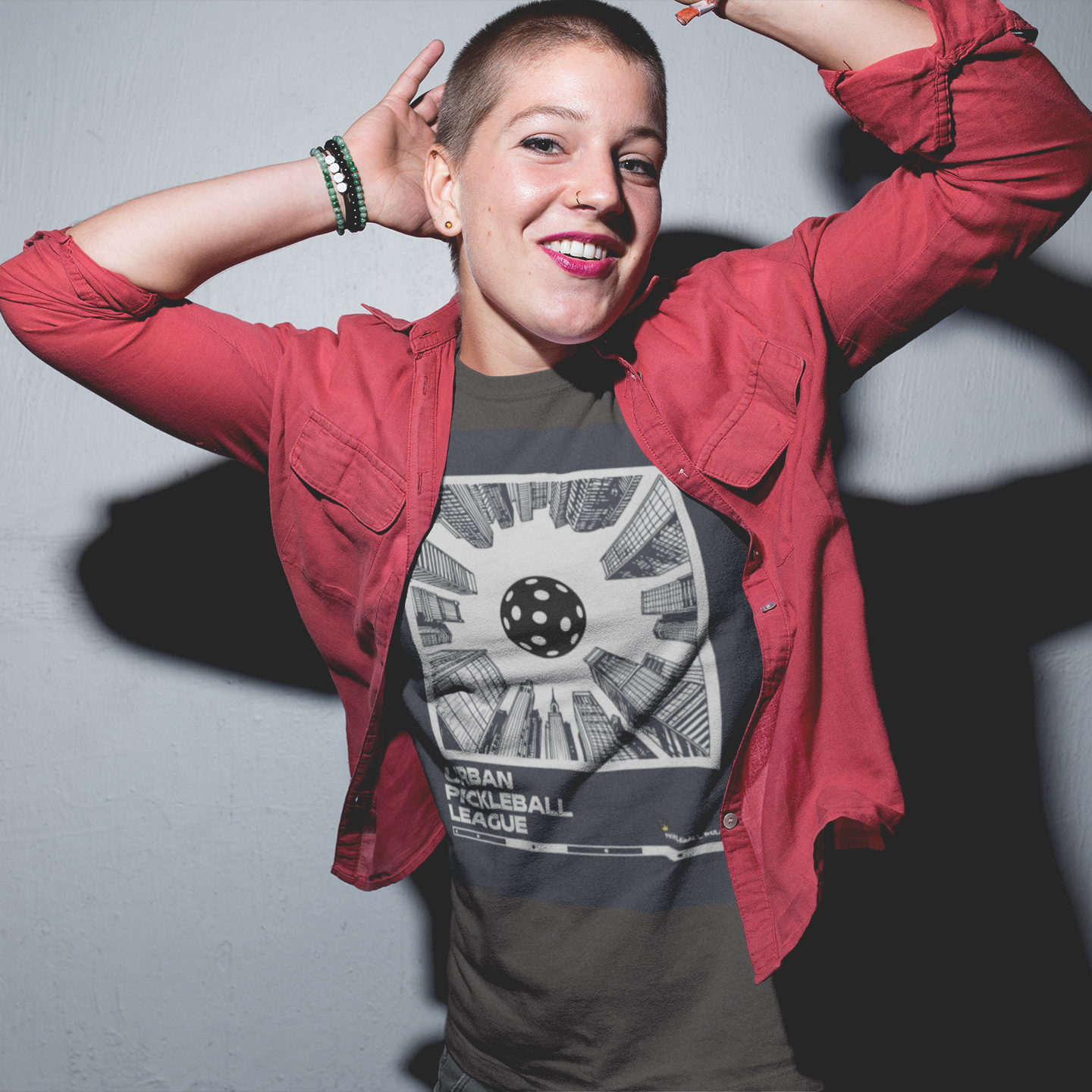 Person wearing a red jacket over a graphic t-shirt with a gray background