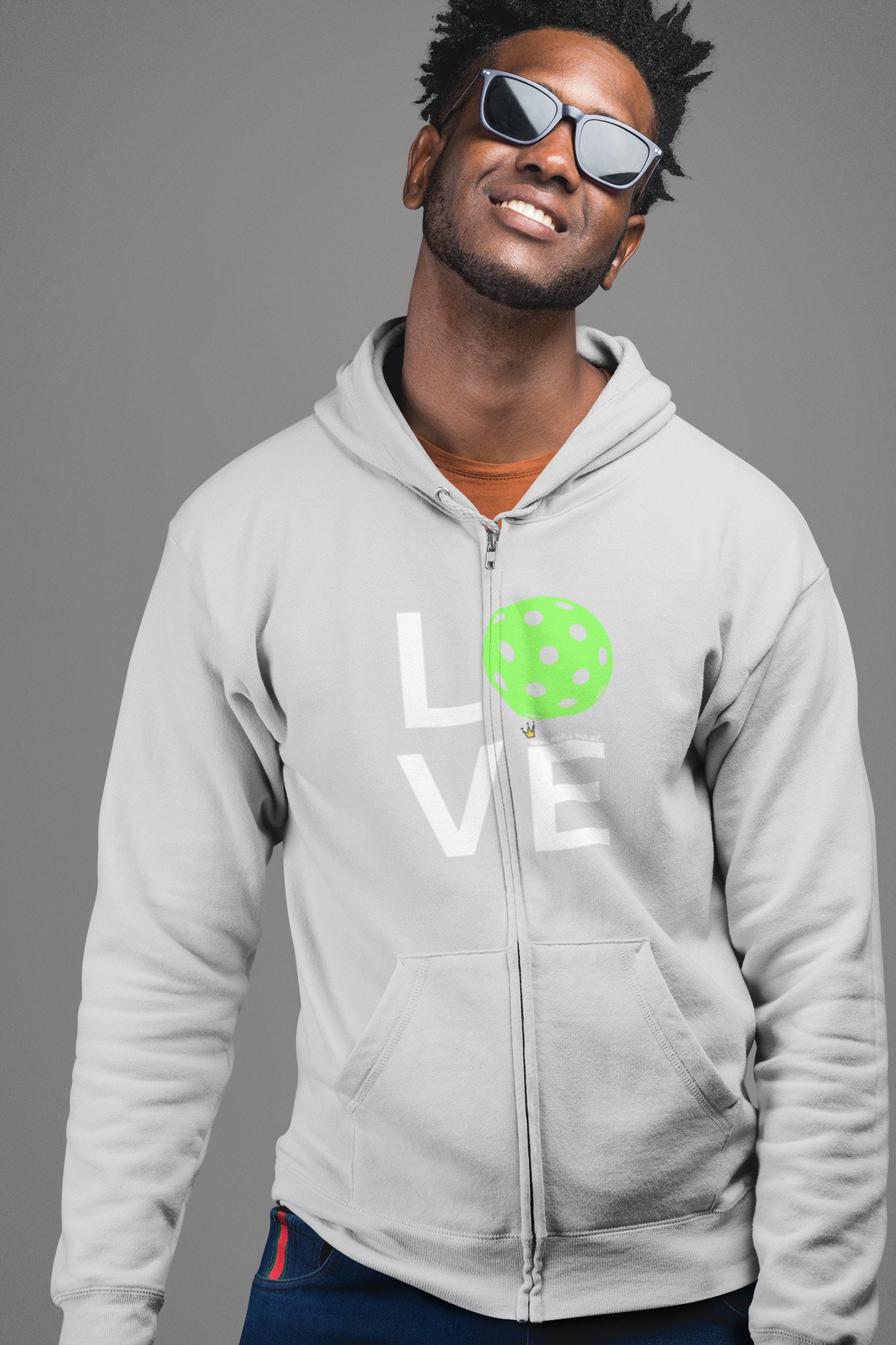 Man wearing a gray hoodie with 'LOVE' printed on it, standing against a gray background
