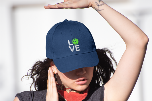 Person wearing a navy blue cap with 'LOVE' printed on it, standing against a light background.