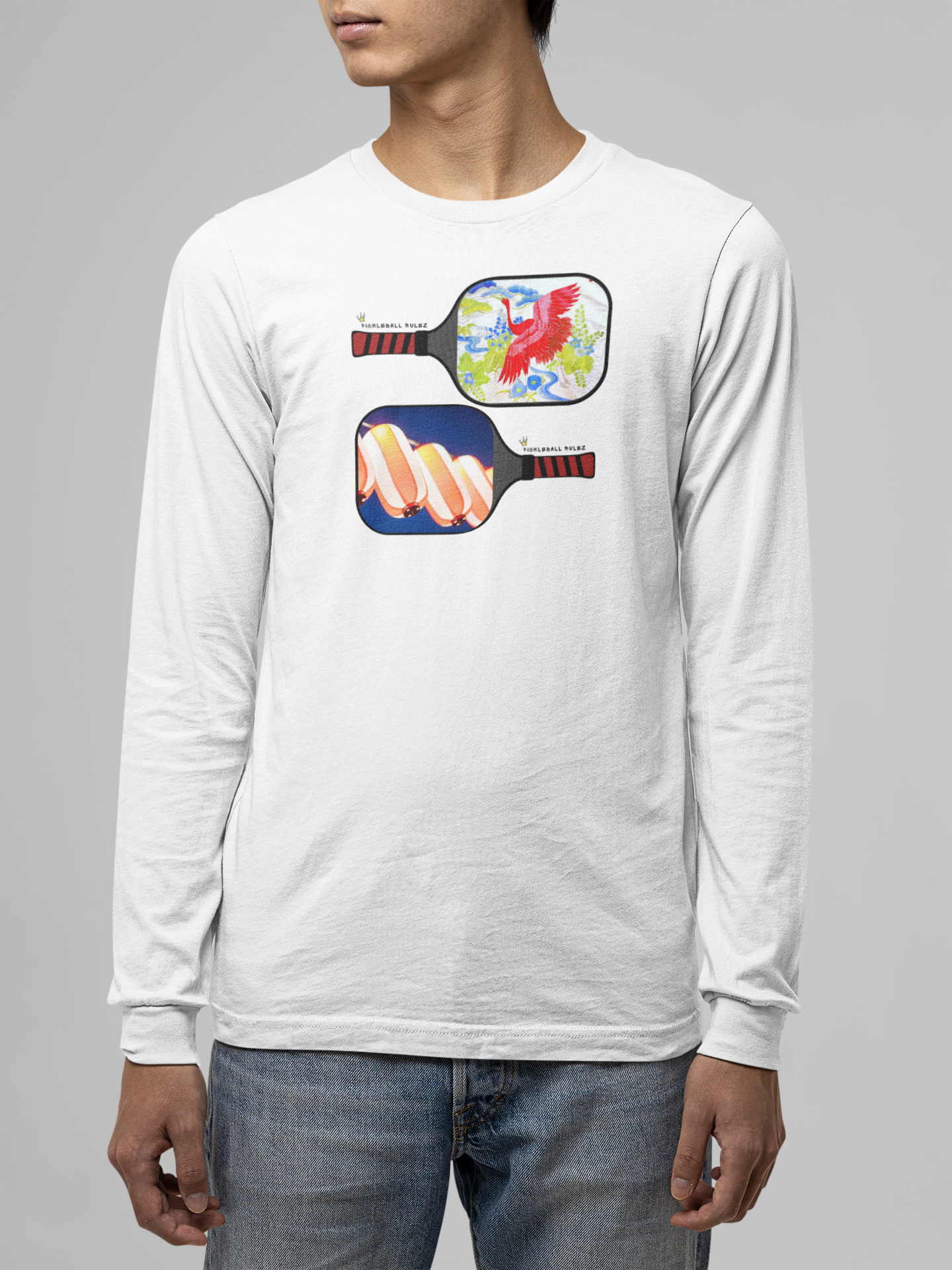 Person wearing a white long-sleeve shirt with pickleball paddle design on a gray background