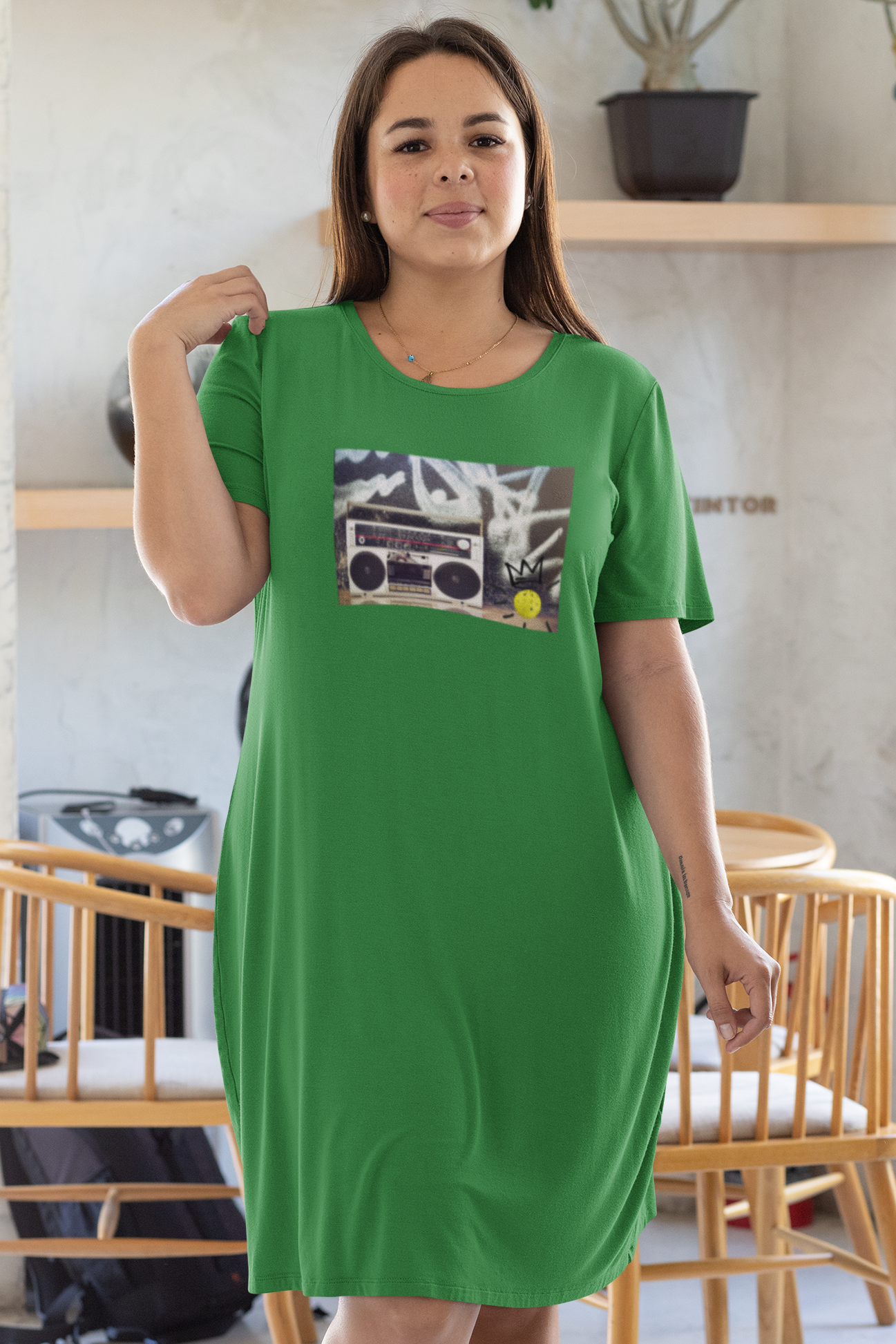 Woman wearing a green dress with a graphic design in a casual indoor setting