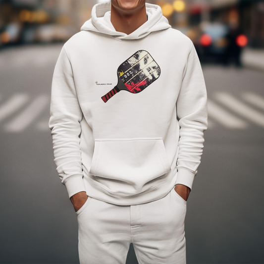 Person wearing a white hoodie with a paddle graphic on a city street.