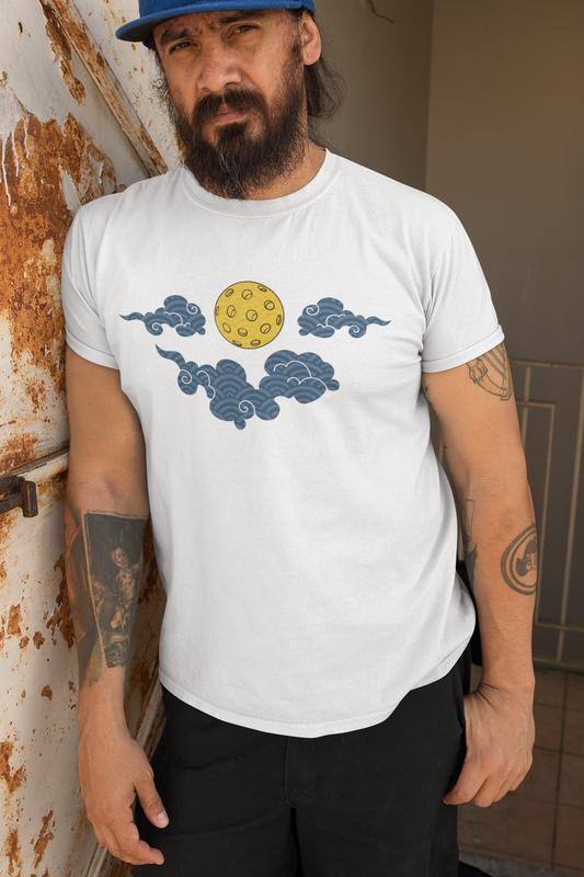 Man wearing a white t-shirt with cloud and sun design, standing against a rusty metal wall.