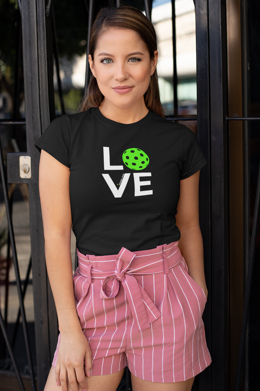 Woman wearing a black t-shirt with 'LOVE' and a green heart graphic, standing outdoors.