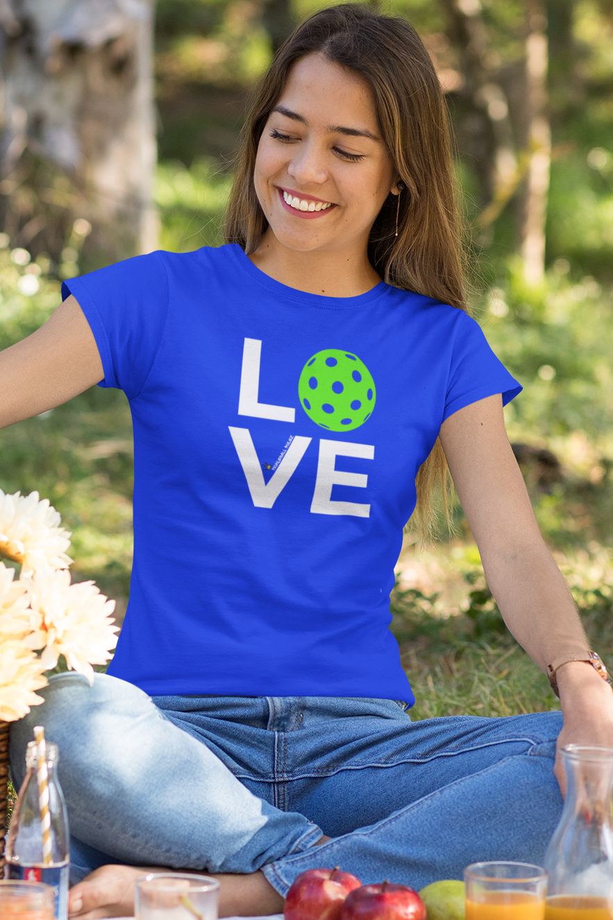 Woman in a blue t-shirt with 'LOVE' printed on it, sitting at a picnic table with food and drinks.