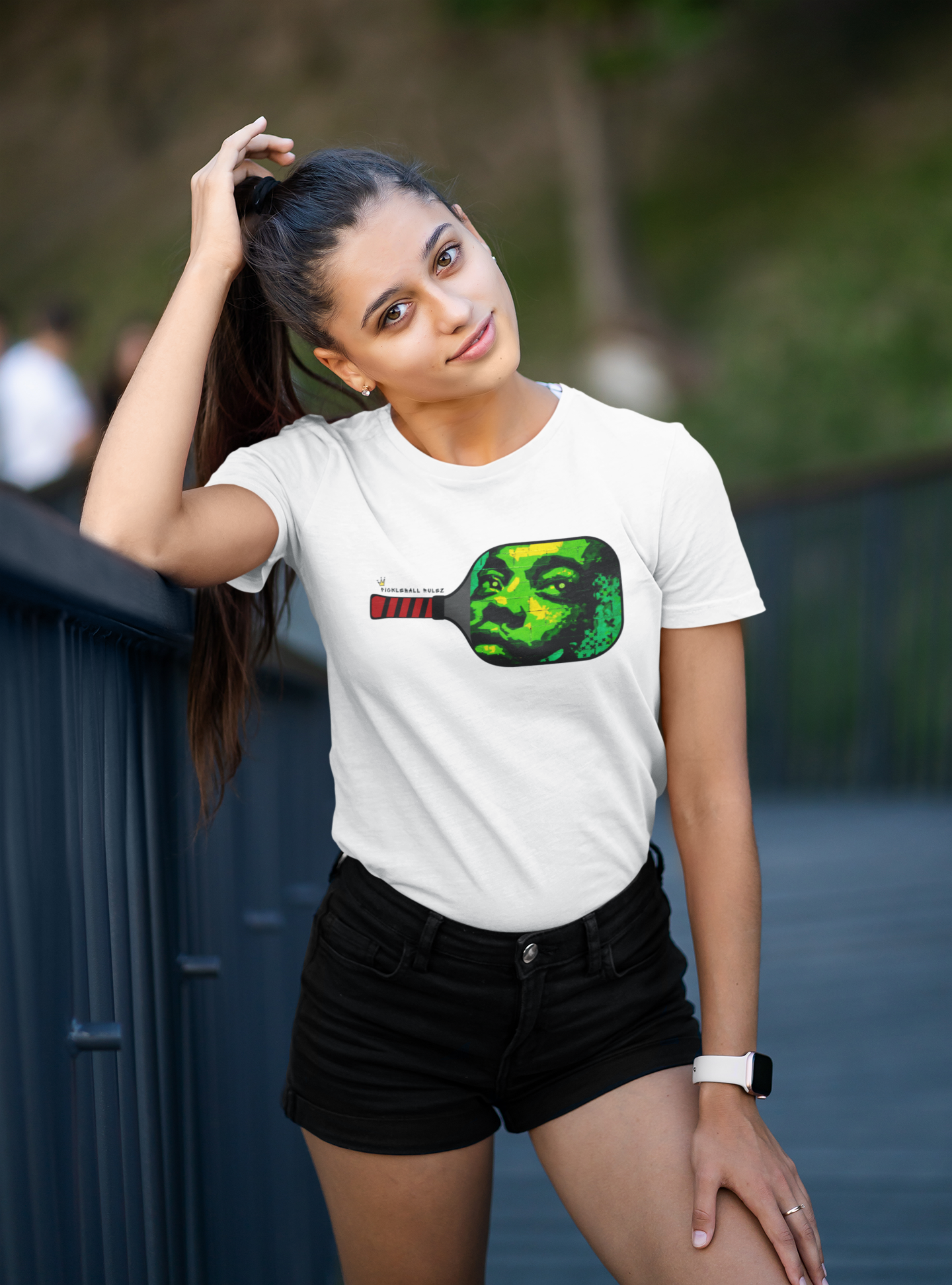 Woman wearing a white t-shirt with a colorful graphic design outdoors