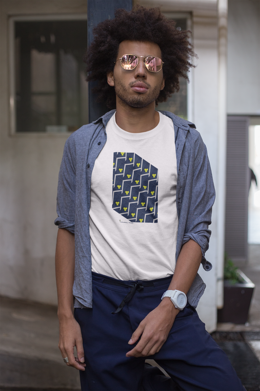 Man wearing a white t-shirt with a blue geometric design, blue shirt, and dark pants outdoors.